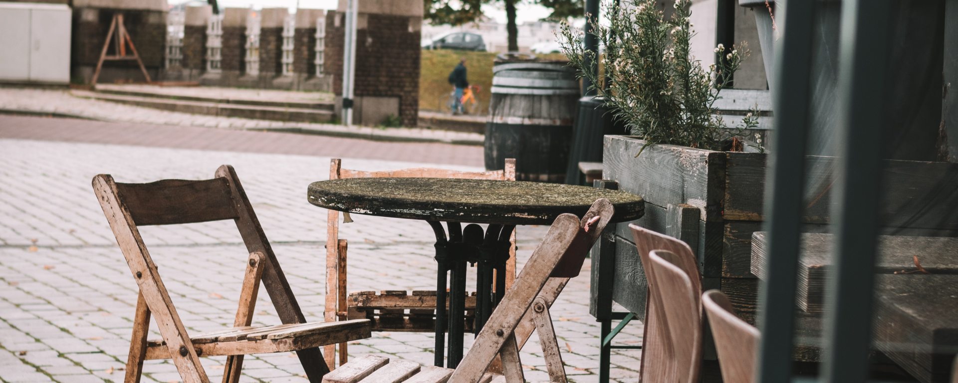 Leeg Terras in Rotterdam in de buurt van de Straatweg. Niet gebruikte houten meubilair, gecombineerd met de luifel in Rotterdams groen-wit geeft een rust of leegte aan.
