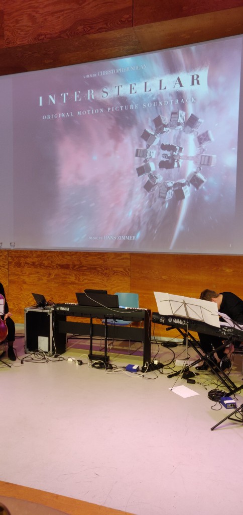 Deel van Doelen Ensemble met Interstellar ruimteschip op een groot scherm