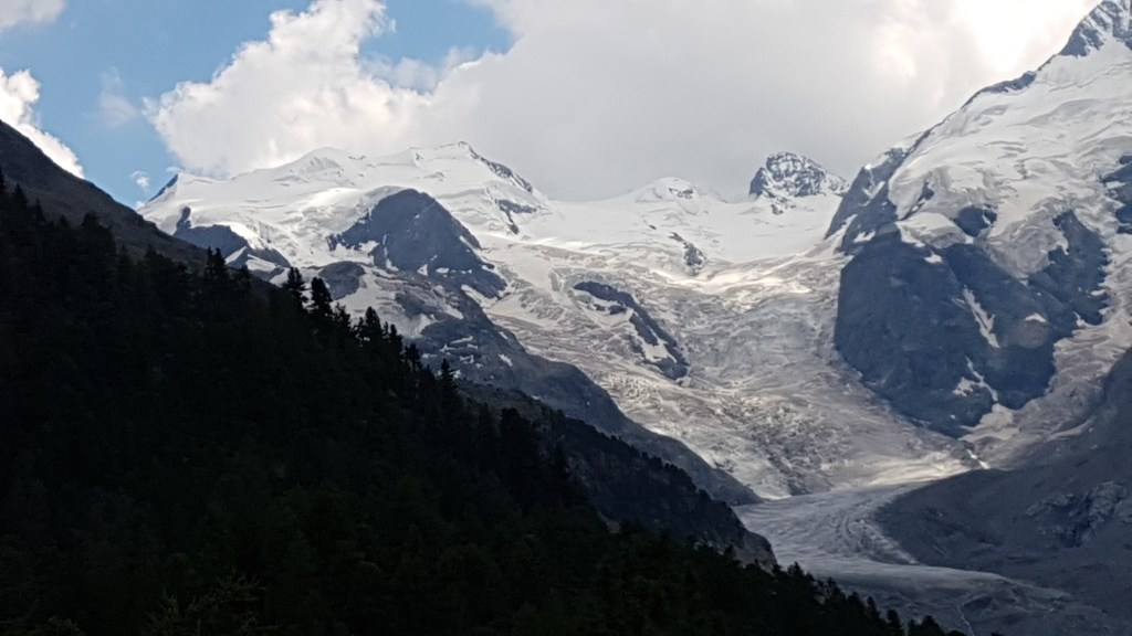 Een alp met flink wat sneeuw. De sneeuw wekt de illusie naar beneden te stromen als smeltwater.