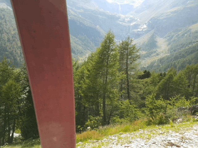 Een rivier in de alpen vanuit de trein. De rivier krompelt zichdoor een dal vanuit de bergen naar een meer.