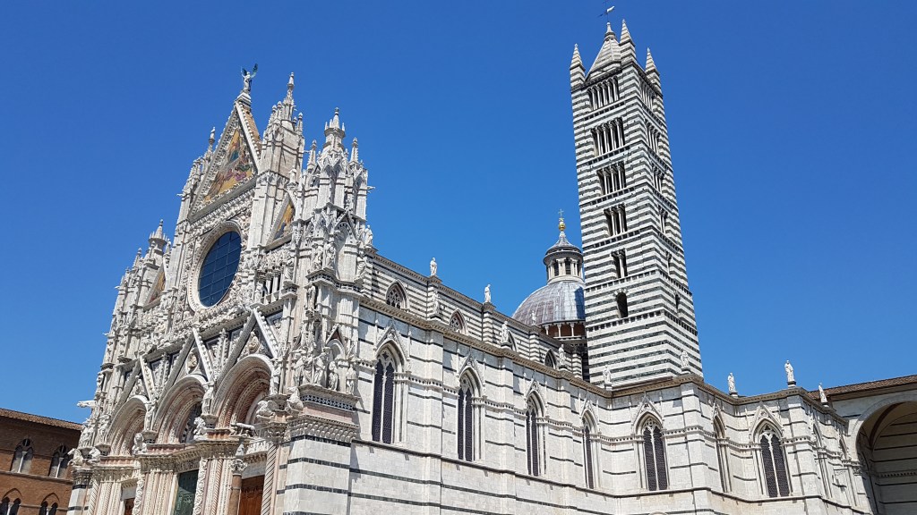 De Kathedraal van Siena of Duomo di Siena. Middeleeuwse catedraal met een koepel, uit wit steen, een gestreepte toren, en een prachtig gedetailleerde façade.