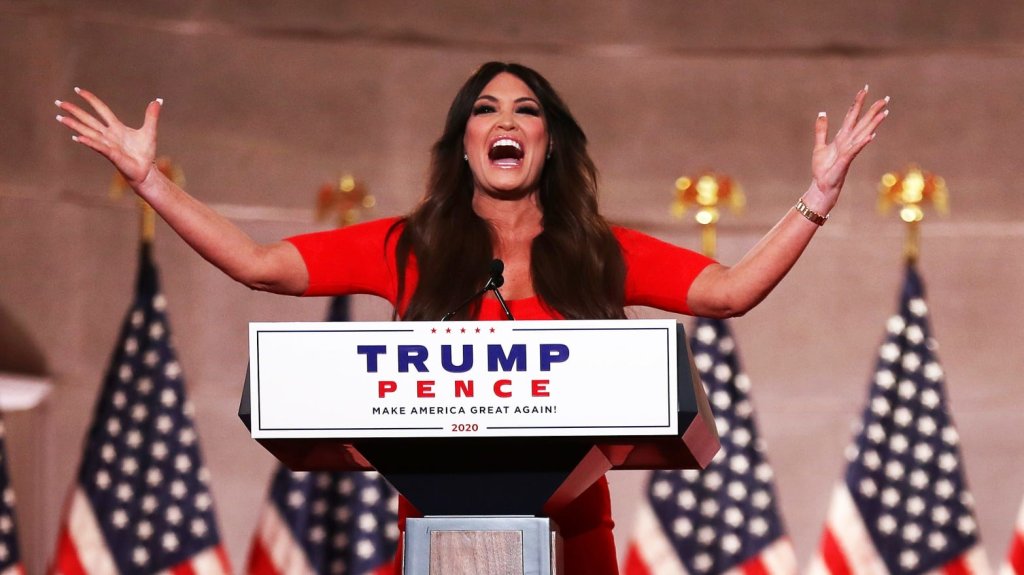 Kimberly Guilfoyle tijdens haar Dwight Schrute-esque speech op het RNC 2020. Ze heeft haar armen in de lucht en gebaart hevig.