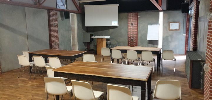 De Workshopruimte, our home away from home voor vandaag. Tafels, stoelen en een scherm.