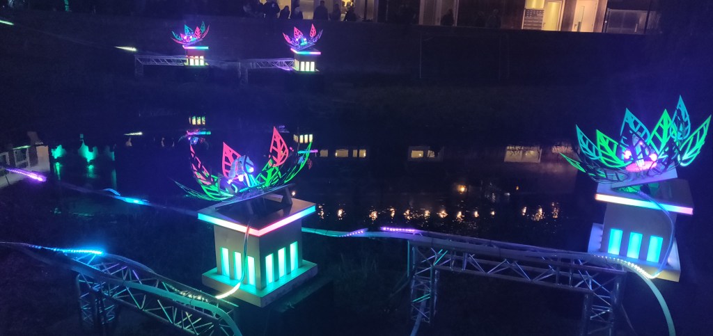 Floral Flow, gestyleerde lichtgevende grote bloemen in verschillende kleuren op het water.