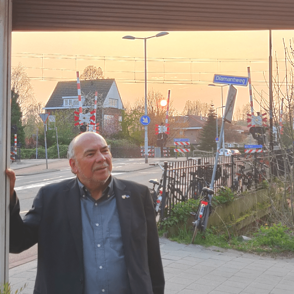 Foto voor het gedicht de man bij de baard. Mijn vader op het feestje van zijn 72ste verjaardag. Hij staat een op een terras in colbert met de achtergrond de ondergaande zon.