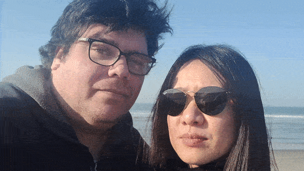 Vi en ik poseren voor een selfie op het strand van Hoek van Holland. Ik laat haar lachen door te kietelen.